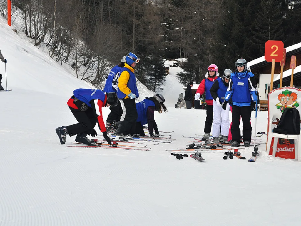 Skigruppe sammelt sich neben einer Pistentafel.